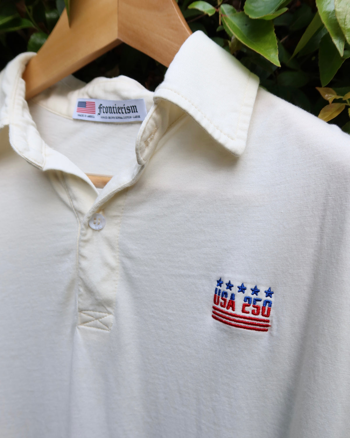 The 250 Polo on a wooden hanger, showing the collar and Frontierism neck label